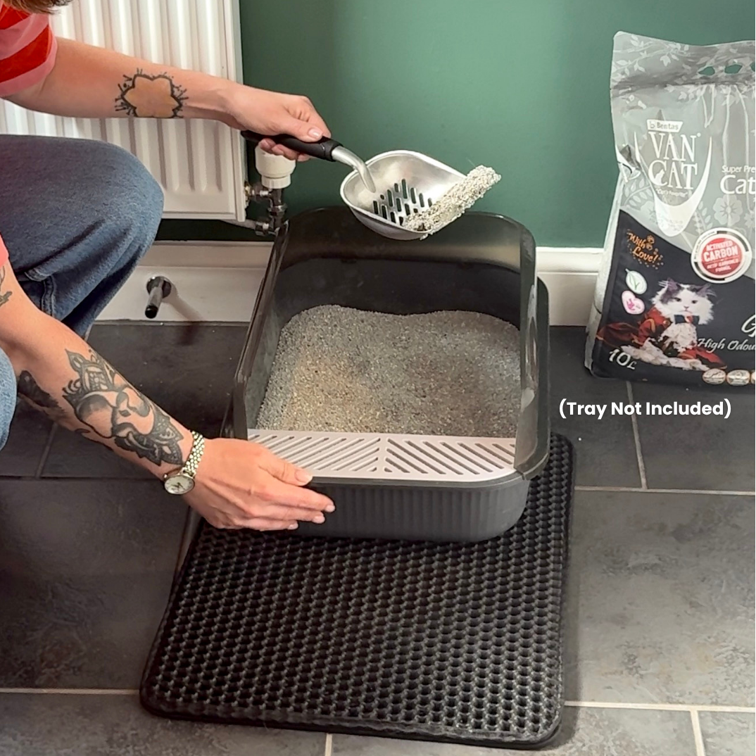 Scooping a neat clump of odour-locking cat litter out of a cat litter box with cat litter, with a package of cat litter visible.
